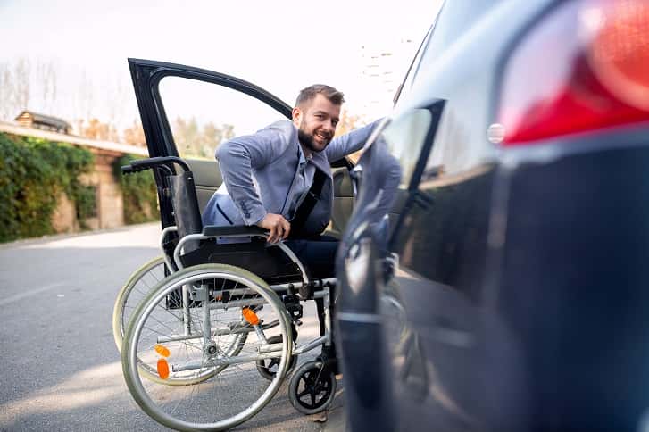 niepełnosprawny wsiada do samochodu